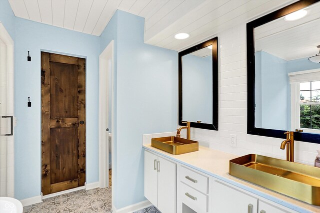 bathroom featuring double vanity, baseboards, and decorative backsplash