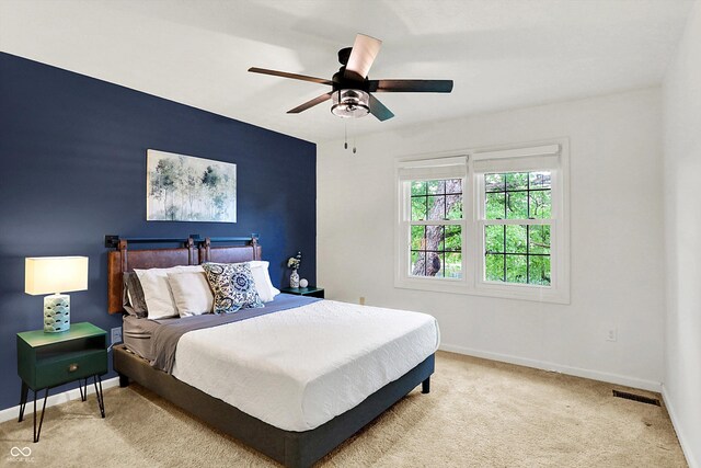 bedroom featuring baseboards, light carpet, and ceiling fan