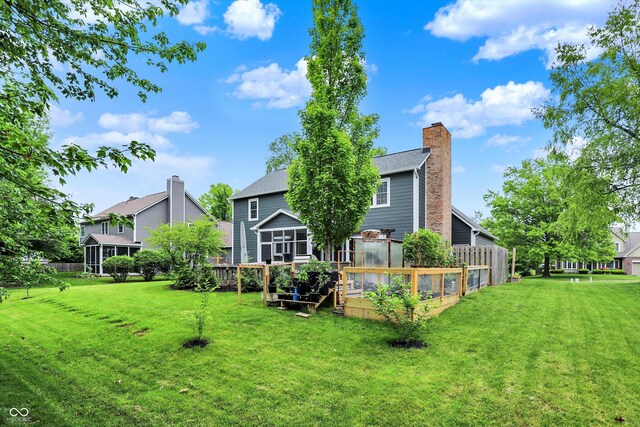 rear view of property featuring a garden and a chimney