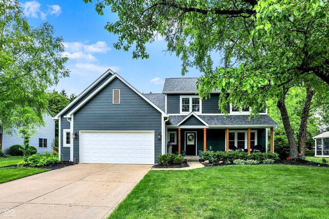 traditional-style home featuring an attached garage, covered porch, concrete driveway, a front lawn, and roof with shingles