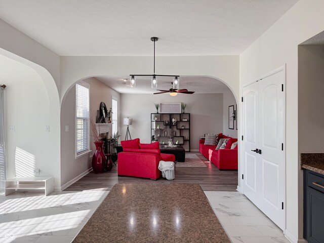 8644 N Deer Crossing Blvd, Mccordsville, IN 46055 - living room featuring arched walkways, a ceiling fan, and baseboards