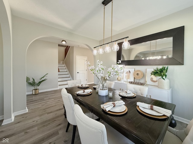 8644 N Deer Crossing Blvd, Mccordsville, IN 46055 - dining area featuring arched walkways, baseboards, wood finished floors, and stairway