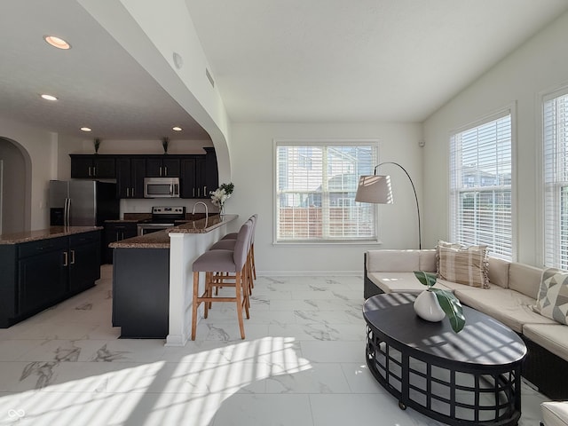 8644 N Deer Crossing Blvd, Mccordsville, IN 46055 - living room with light marble finish flooring, arched walkways, plenty of natural light, recessed lighting, and baseboards