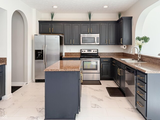 8644 N Deer Crossing Blvd, Mccordsville, IN 46055 - kitchen featuring appliances with stainless steel finishes, a sink, light marble finish flooring, arched walkways, and recessed lighting