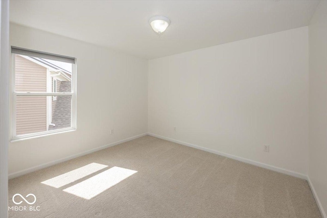 unfurnished room with carpet flooring and baseboards