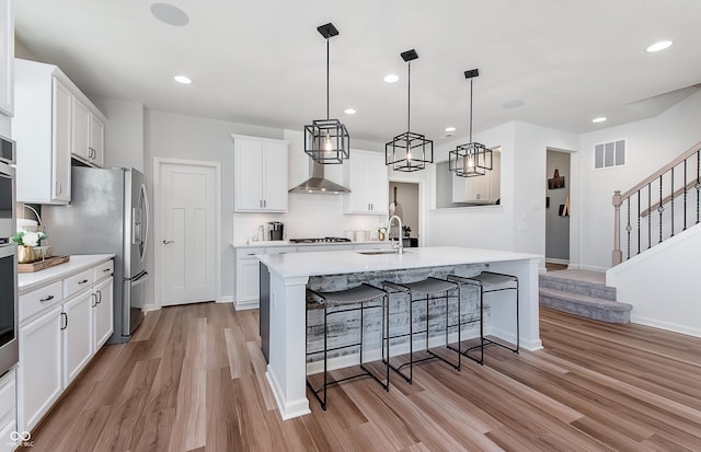 kitchen featuring a kitchen bar, light wood-style floors, light countertops, a sink, and white cabinets