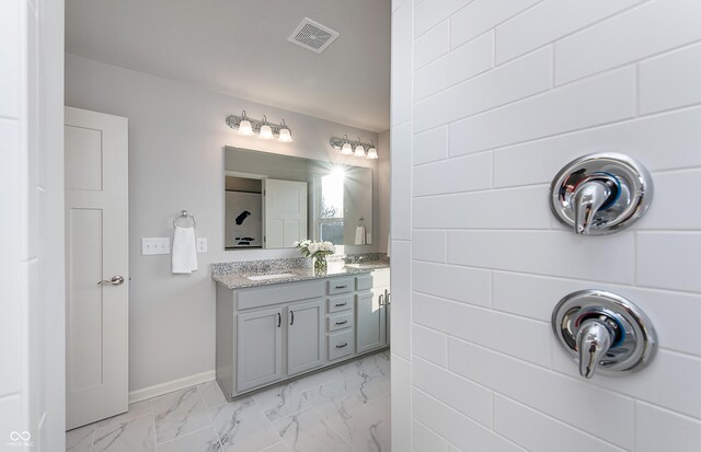 bathroom featuring vanity, marble look tiles, and baseboards