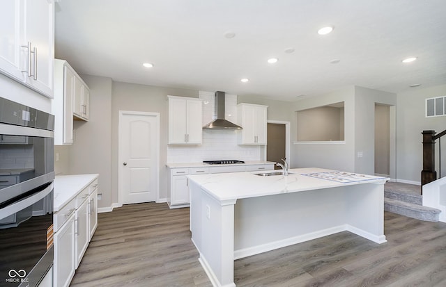 3256 Fawn Cir, Brownsburg, IN 46112 - kitchen with wall chimney range hood, double wall oven, backsplash, a sink, and light wood-style flooring