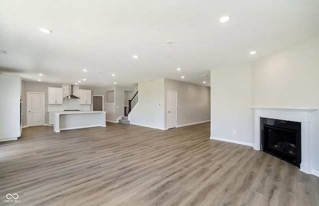 3256 Fawn Cir, Brownsburg, IN 46112 - unfurnished living room with recessed lighting, light wood-style flooring, a fireplace, stairway, and baseboards