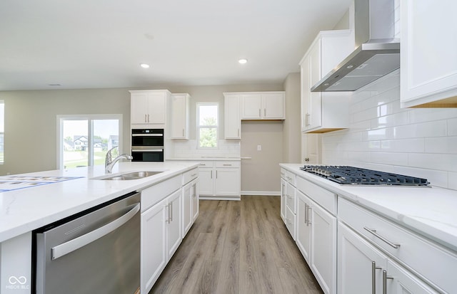 3256 Fawn Cir, Brownsburg, IN 46112 - kitchen featuring appliances with stainless steel finishes, wall chimney range hood, a sink, tasteful backsplash, and white cabinetry