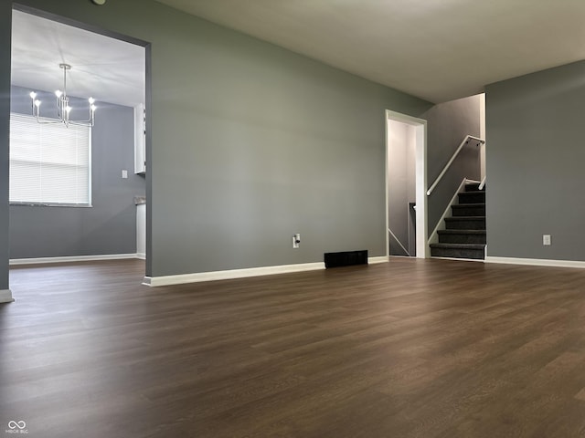 8417 S Sherman Dr, Indianapolis, IN 46237 - unfurnished living room with stairway, a chandelier, baseboards, and dark wood-style flooring