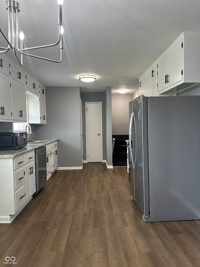 8417 S Sherman Dr, Indianapolis, IN 46237 - kitchen with appliances with stainless steel finishes, dark wood-style floors, a sink, and white cabinetry