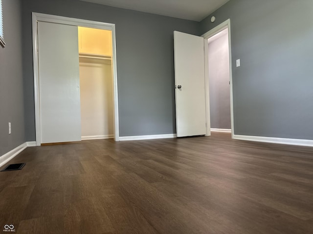 8417 S Sherman Dr, Indianapolis, IN 46237 - unfurnished bedroom with dark wood finished floors, baseboards, and a closet