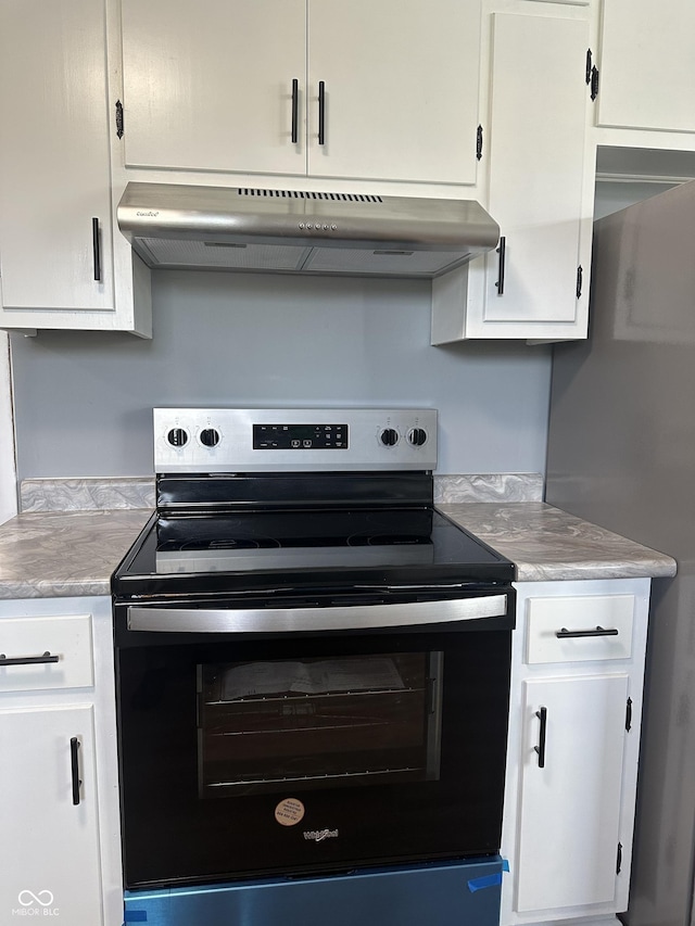 8417 S Sherman Dr, Indianapolis, IN 46237 - kitchen with electric stove, under cabinet range hood, light countertops, white cabinetry, and refrigerator