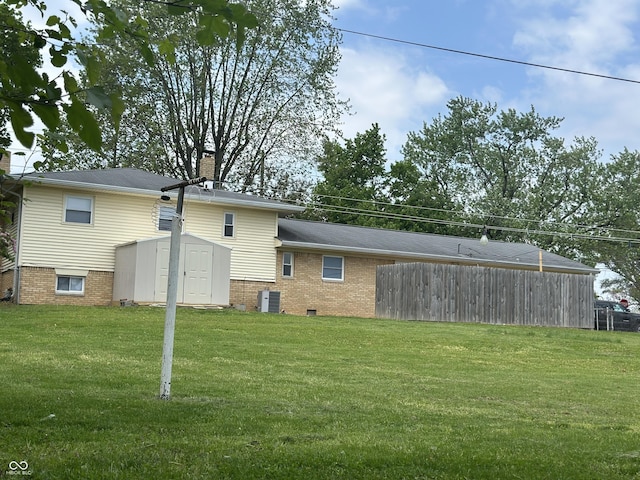 8417 S Sherman Dr, Indianapolis, IN 46237 - back of property with a storage shed, a chimney, a lawn, an outdoor structure, and brick siding