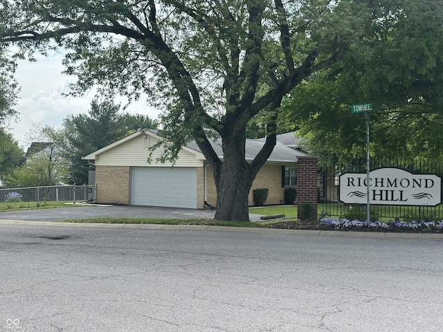 8417 S Sherman Dr, Indianapolis, IN 46237 - view of front facade with fence, brick siding, a garage, and asphalt driveway