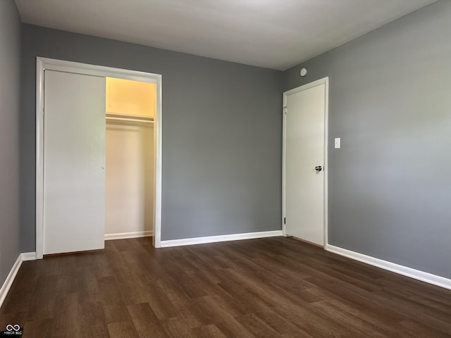 8417 S Sherman Dr, Indianapolis, IN 46237 - unfurnished bedroom featuring dark wood-type flooring, baseboards, and a closet