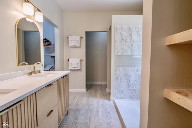 full bath with wood finished floors, double vanity, and a walk in shower