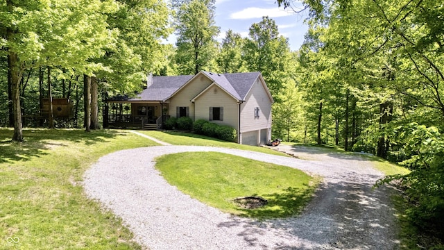 ranch-style house featuring curved driveway, a garage, a front lawn, and covered porch