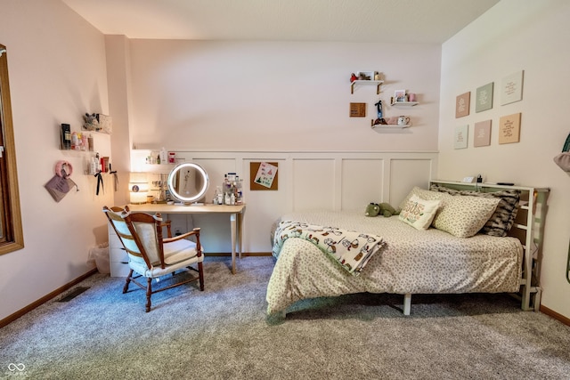 bedroom featuring carpet, a wainscoted wall, and a decorative wall