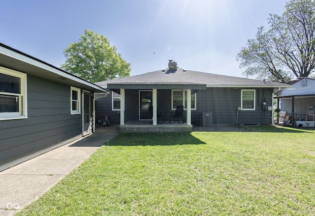 370 N Bazil Ave, Indianapolis, IN 46219 - rear view of house featuring a lawn and a chimney