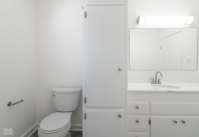 370 N Bazil Ave, Indianapolis, IN 46219 - bathroom featuring baseboards, vanity, and toilet