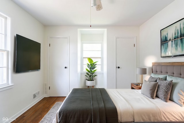 370 N Bazil Ave, Indianapolis, IN 46219 - bedroom with multiple windows, dark wood-type flooring, and baseboards
