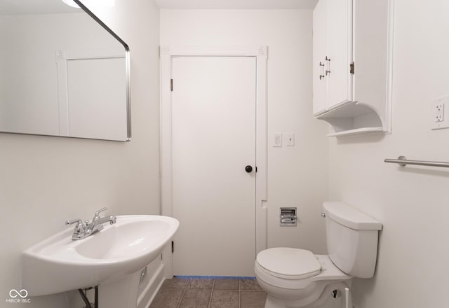 370 N Bazil Ave, Indianapolis, IN 46219 - half bathroom featuring toilet, a sink, and tile patterned flooring