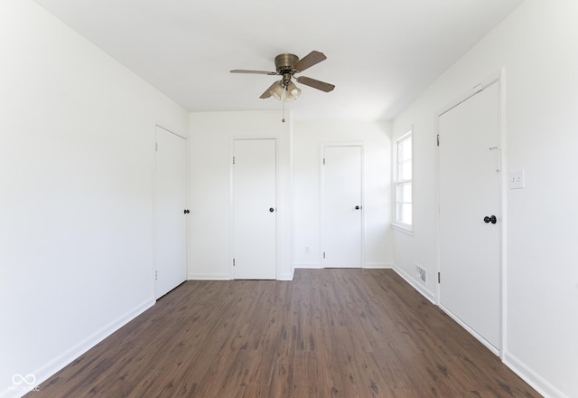 370 N Bazil Ave, Indianapolis, IN 46219 - unfurnished bedroom featuring dark wood finished floors, baseboards, and a ceiling fan