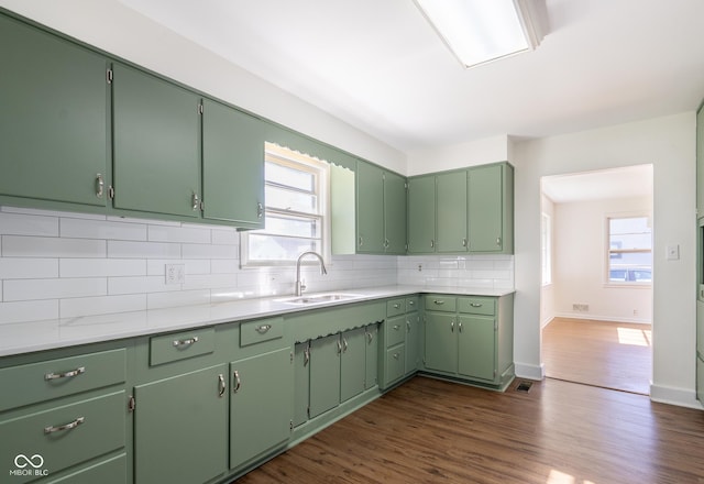 370 N Bazil Ave, Indianapolis, IN 46219 - kitchen featuring a sink, decorative backsplash, light countertops, dark wood-style floors, and baseboards