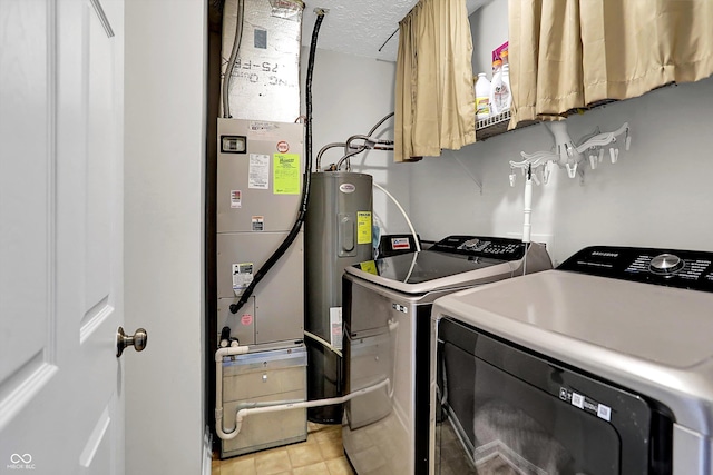 washroom featuring independent washer and dryer, electric water heater, and a textured ceiling