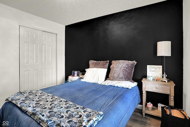 bedroom featuring wood finished floors, a closet, and baseboards