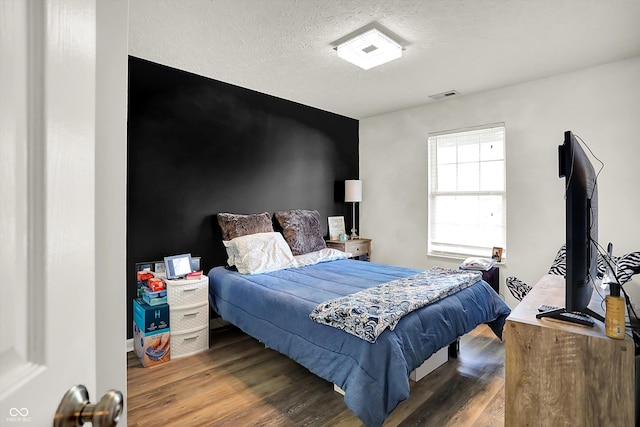 bedroom with wood finished floors and a textured ceiling