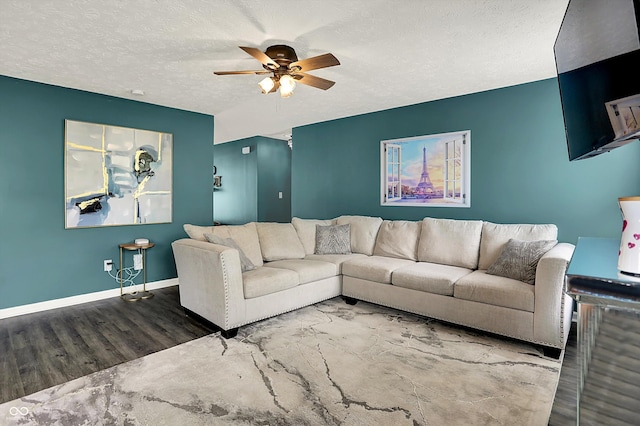 living area with wood finished floors, ceiling fan, a textured ceiling, and baseboards