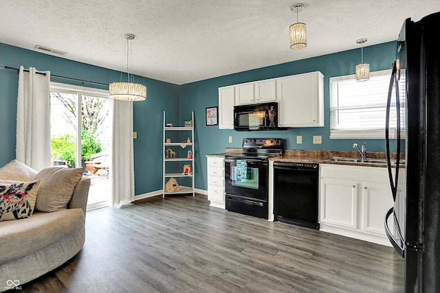 kitchen with black appliances, a sink, white cabinetry, dark countertops, and a textured ceiling