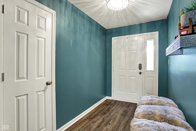 foyer entrance featuring dark wood finished floors and baseboards