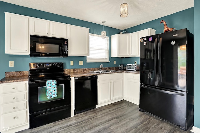 kitchen featuring black appliances, dark countertops, a sink, white cabinetry, and a textured ceiling