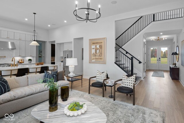 9602 Fall Creek Rd, Indianapolis, IN 46256 - living room with a chandelier, stairway, light wood-type flooring, recessed lighting, and baseboards