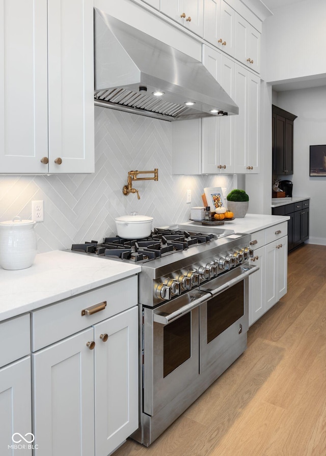 9602 Fall Creek Rd, Indianapolis, IN 46256 - kitchen featuring double oven range, exhaust hood, backsplash, light wood-style flooring, and light stone counters
