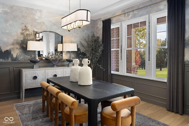 9602 Fall Creek Rd, Indianapolis, IN 46256 - dining space featuring wallpapered walls, a decorative wall, light wood finished floors, a chandelier, and wainscoting