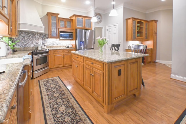 1614 Rosebud Ln Unit 83, Greenwood, IN 46143 - kitchen featuring stainless steel appliances, custom range hood, light wood-type flooring, brown cabinetry, and a center island