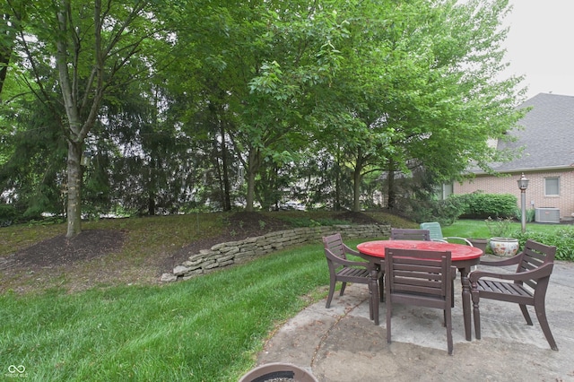 1614 Rosebud Ln Unit 83, Greenwood, IN 46143 - view of green lawn with outdoor dining area, central air condition unit, and a patio