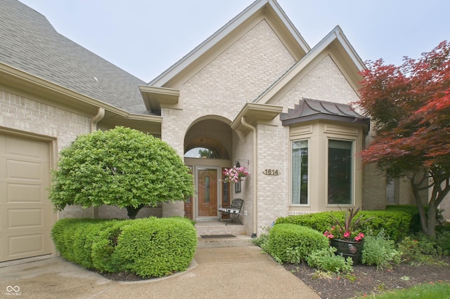 1614 Rosebud Ln Unit 83, Greenwood, IN 46143 - view of exterior entry featuring roof with shingles, a standing seam roof, and brick siding
