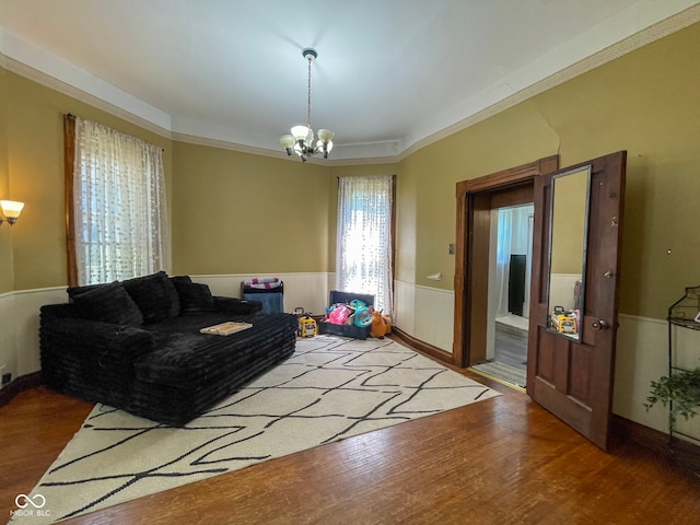living room with a chandelier, wainscoting, and wood finished floors