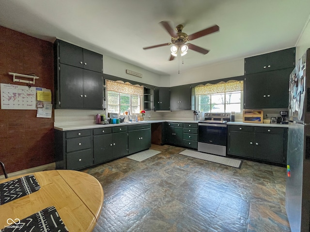 kitchen featuring stainless steel electric range, ceiling fan, healthy amount of natural light, and light countertops