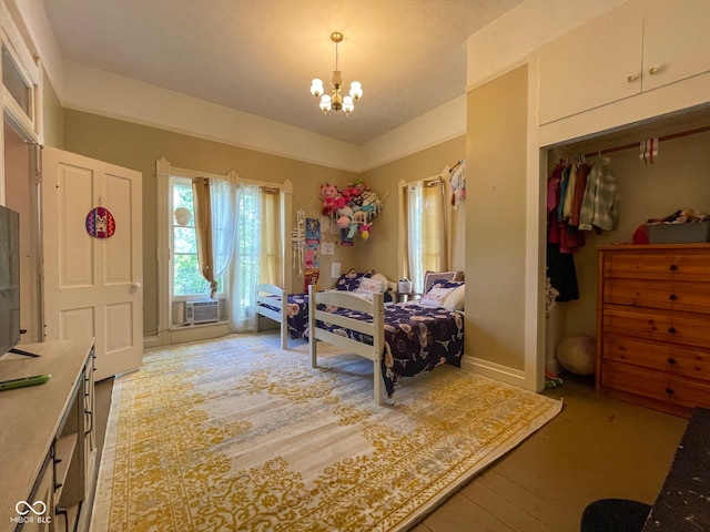 bedroom with a chandelier, cooling unit, and light wood-type flooring