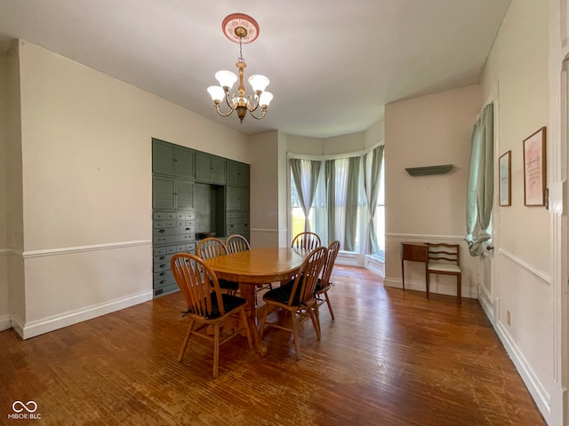 dining area featuring a chandelier, dark wood-style floors, and baseboards