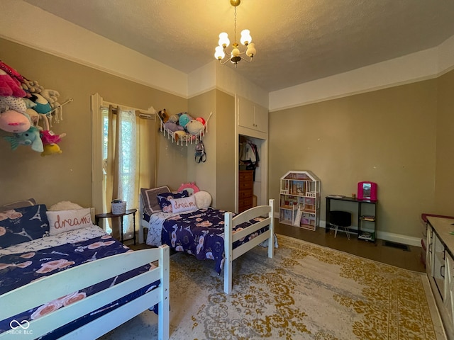 bedroom with a chandelier and a textured ceiling