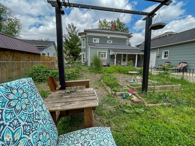 rear view of house with a chimney and fence