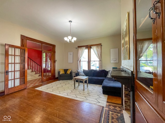 living room featuring wood finished floors, stairway, and a chandelier